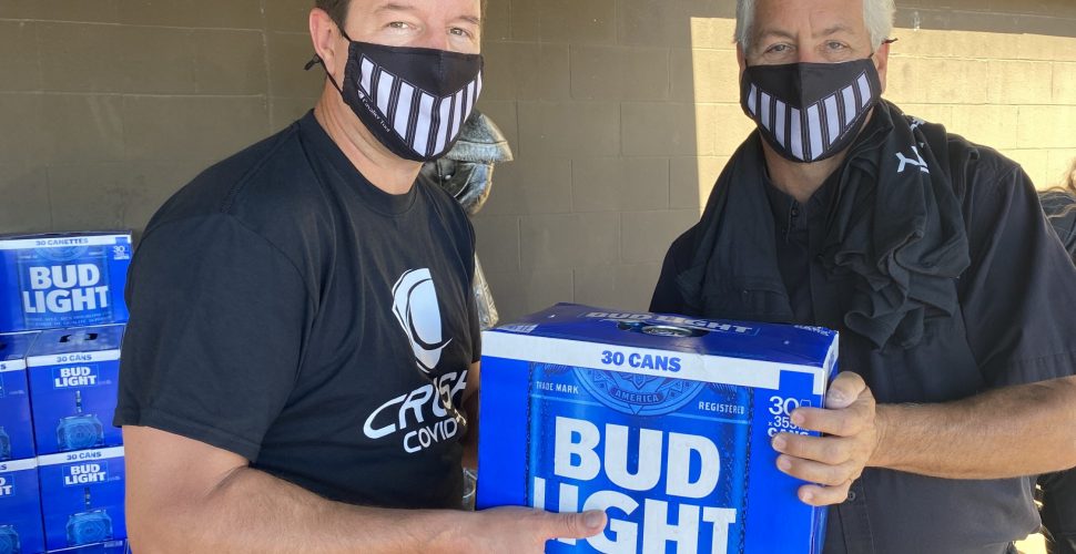 Cavalier Tool President Brian Bendig handing a case of Bud Light to a Cavalier Staff Member.
