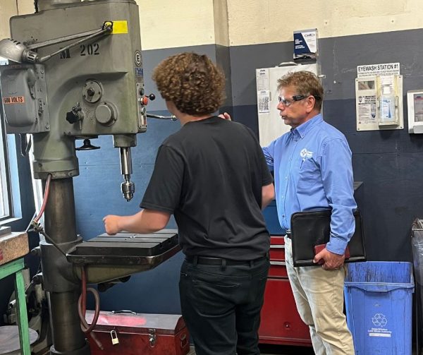 Career Ready Participant Logan Best showing CTMA Monitor Richard Janik a machine he works with in the detail room at Cavalier Tool.